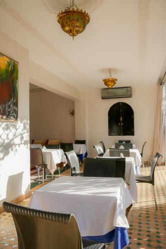 a dining room with tables and chairs and a chandelier at RIAD REDWAN in Marrakech