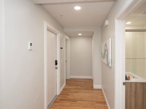 an empty hallway with white walls and wood floors at Jennifer's College Hill Apartment Close to Everything in Providence