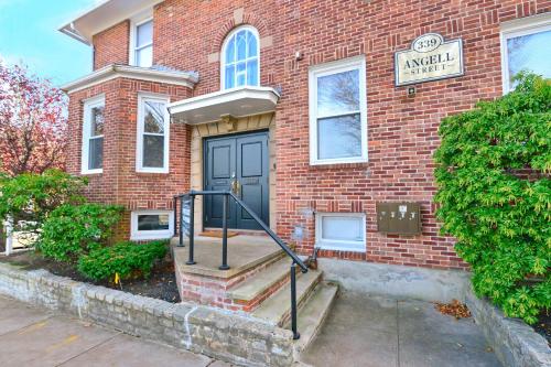 a brick house with a black door and stairs in front at Jennifer's College Hill Apartment Close to Everything in Providence