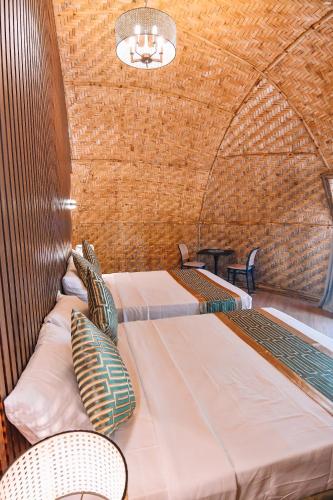 a room with two beds and two chairs at The Dome Hotel - Caylabne Bay in Ternate
