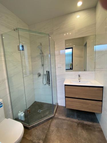 a bathroom with a shower and a sink and a toilet at CozyNest3 -Private entrance and bath in Auckland