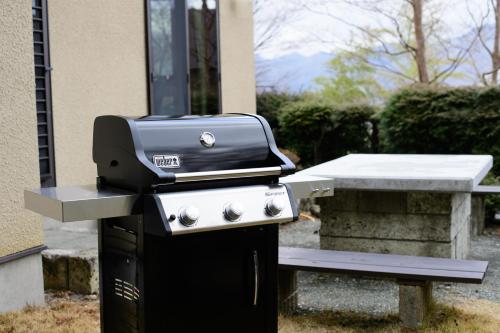a grill sitting next to a picnic table at Hakone Ninotaira Cottage in Onsensō