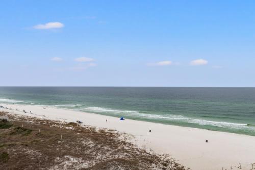 a beach with a group of people in the ocean at Pinnacle Port, A-708 in Carillon Beach