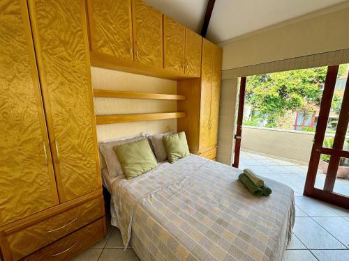 a bedroom with a bed and a large window at Duplex incrível a 5 min do centro com piscina in Nova Friburgo
