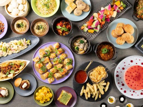 a table topped with plates of food and bowls of food at Grand Mercure Nara Kashihara in Kashihara