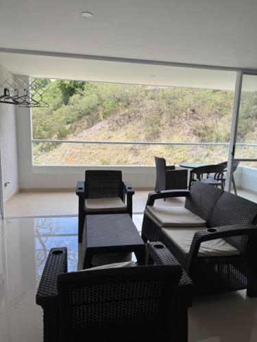 a room with black chairs and a large window at Citadela Disole Paraíso in Santa Fe de Antioquia