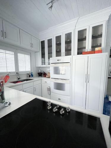 a kitchen with white cabinets and a pair of shoes at Beautiful Villa by the Beach in Nassau
