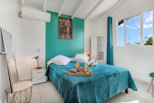 ein Schlafzimmer mit einem Bett, auf dem ein Tablett mit Essen steht in der Unterkunft Villa Gosier T3- Vue Nature - Romantique in Le Gosier