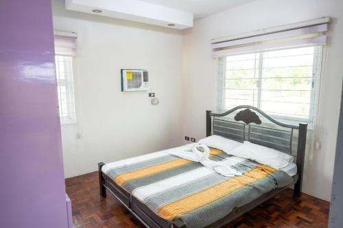 a bedroom with a bed in a room with windows at La Casa Vacanze Ph in Batangas City 5BR with Pool in Batangas City