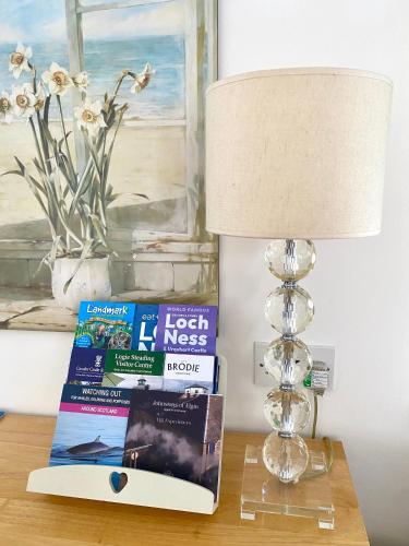 a lamp sitting on a table with a book and a lamp at Glenburn, Fochabers in Fochabers