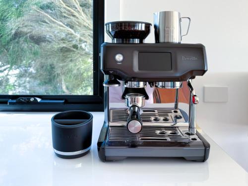 a coffee maker sitting on a counter next to a cup at Pearl Hawley Beach in Port Sorell