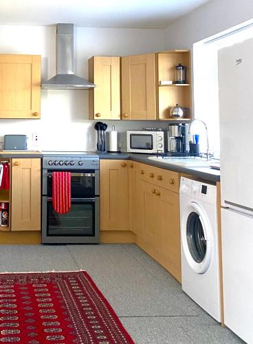 a kitchen with a stove and a washing machine at Glenburn, Fochabers in Fochabers