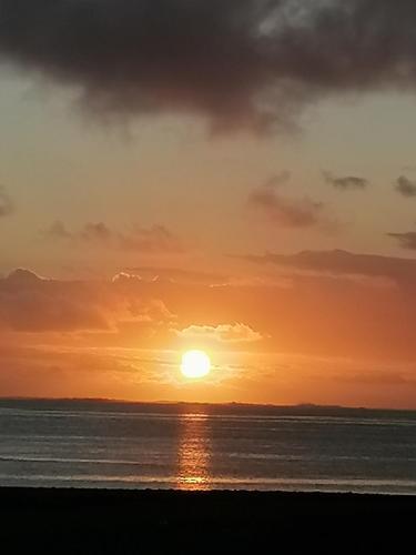 a sunset on the beach with the sun setting at studio maryphil in Saint-Martin