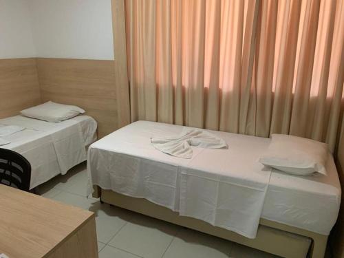 una stanza con due letti e una finestra di Beach Class Convention HOM a Recife