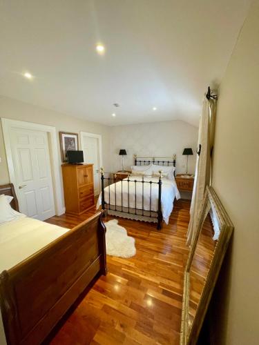 a bedroom with two beds and a wooden floor at The Shores Country House in Castlegregory