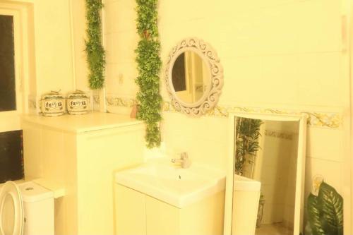 a white bathroom with a sink and a mirror at Homestay Central in Cambridge
