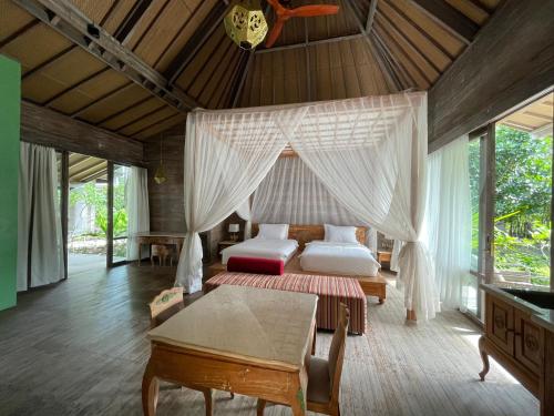 a bedroom with two beds and a table at Mega Resort Karimunjawa in Karimunjawa