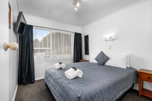 a bedroom with a bed with two towels on it at Aspen on King in Timaru