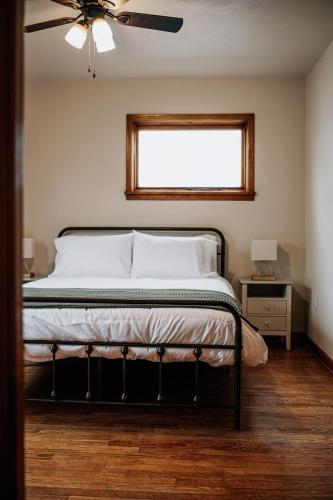 a bedroom with a bed with a ceiling fan and a window at The Mueller Haus in Hermann