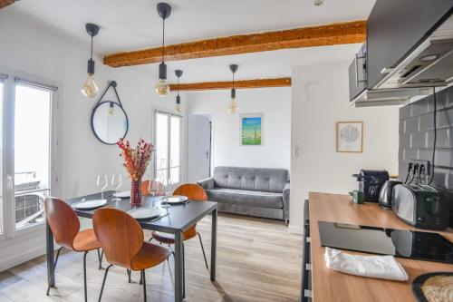 une cuisine et un salon avec une table et des chaises dans l'établissement Le Breteuil - Appart standing proche Vieux-Port, à Marseille