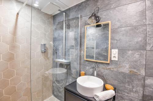 une salle de bain avec une douche, un lavabo et un miroir dans l'établissement Le Breteuil - Appart standing proche Vieux-Port, à Marseille