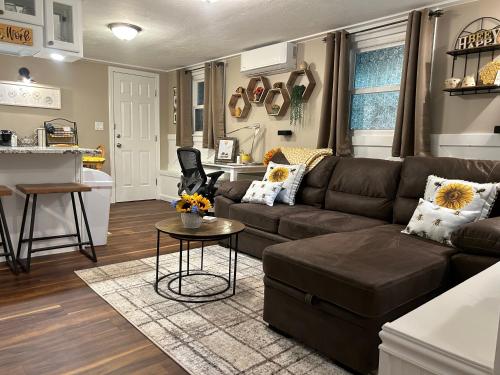 a living room with a brown couch and a table at The Hive - Unique Themed Getaway in Billerica