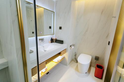 a white bathroom with a sink and a toilet at Ramada by Wyndham Vientiane Central in Vientiane