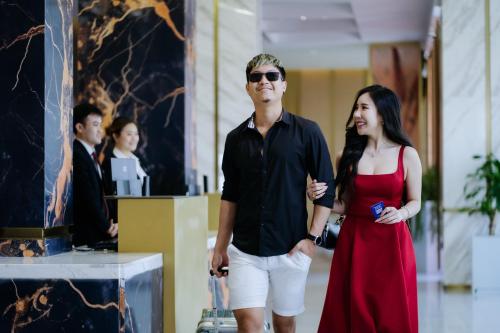 a man and a woman walking through a lobby at Ramada by Wyndham Vientiane Central in Vientiane