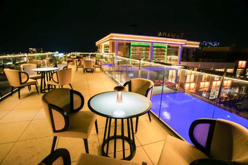 a table and chairs on a balcony at night at Ramada by Wyndham Vientiane Central in Vientiane