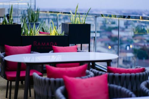 a couple of tables and chairs with pink pillows at Ramada by Wyndham Vientiane Central in Vientiane