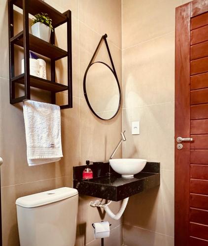 a bathroom with a sink and a toilet and a mirror at Sorte e Amaro in Santo Amaro