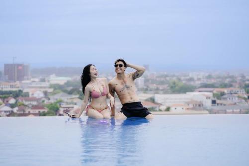 a man and a woman sitting in the water at Ramada by Wyndham Vientiane Central in Vientiane