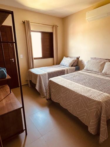 a bedroom with two beds and a window at Sorte e Amaro in Santo Amaro