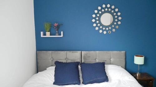 a blue bedroom with a bed with two blue pillows at Stoke - 3 Bedroom House - Winifred St. in Stoke on Trent