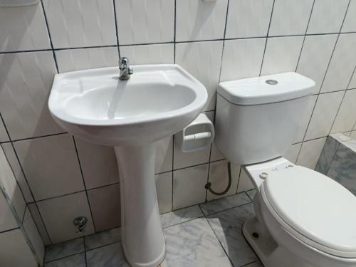 a bathroom with a white sink and a toilet at Hospedaje Cielo Marino in Zorritos