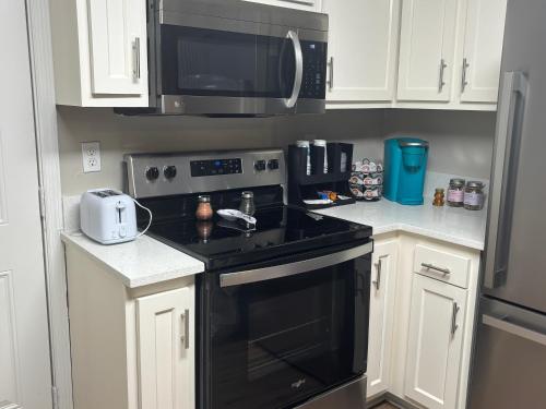 a kitchen with a black stove and a microwave at LED Lighting Reclining Sofas Cozy 3 Bedroom Home in Jacksonville