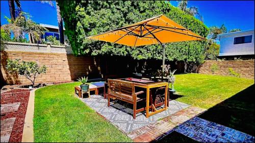 a patio with an umbrella and a table in a yard at Pet-Friendly Beach Home with Fenced Yard in Huntington Beach