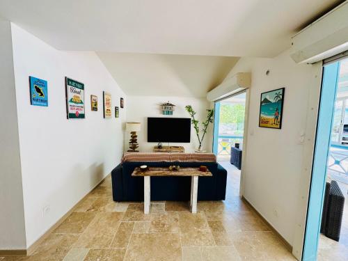 a living room with a couch and a tv at Villa Yaya in Le Robert