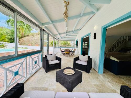 a screened in porch with chairs and a table at Villa Yaya in Le Robert