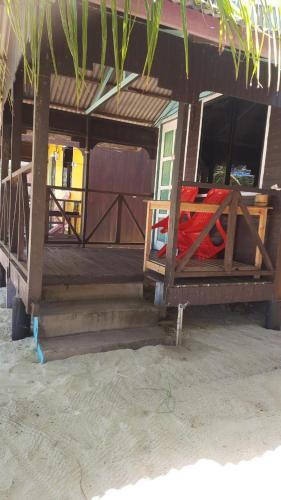a house on the beach with a bed in it at Rainbow Tioman Cottage in Kampong Juara