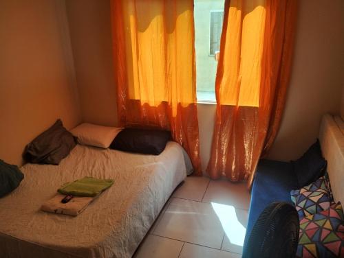 ein kleines Zimmer mit zwei Betten und einem Fenster in der Unterkunft Apartamento completo na praia in Mangaratiba