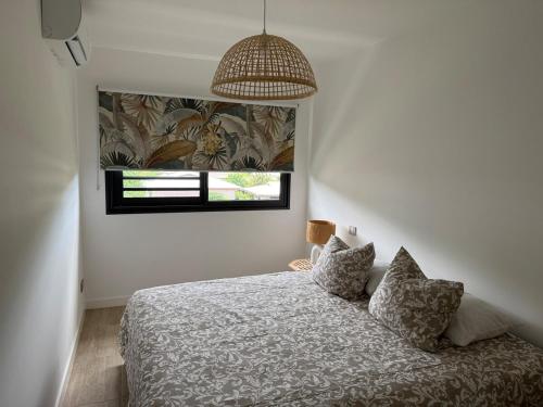 una camera da letto con un letto e una finestra di Arbre a pain Beach Lodge a Punaauia