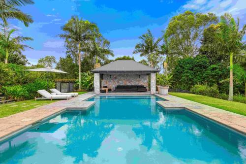 a swimming pool in a backyard with a gazebo at Brightside Holidays in Landsborough