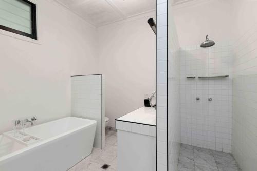 a white bathroom with a tub and a sink at Brightside Holidays in Landsborough