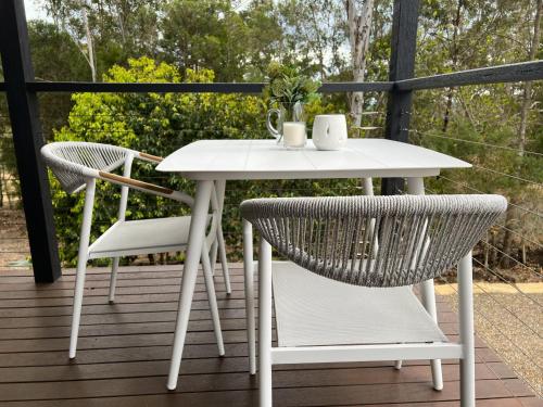 a white table and two chairs on a deck at Brightside Holidays in Landsborough