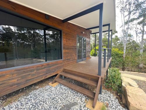 a wooden porch with a bench on a house at Brightside Holidays in Landsborough