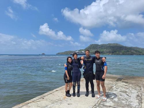a group of people standing on a pier near the water at La Posada del Buzo in Colón