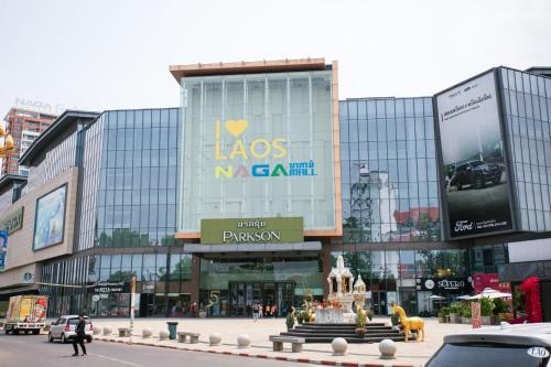 a large glass building with a fountain in front of it at Ramada by Wyndham Vientiane Central in Vientiane