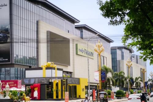 a building on a city street with cars and buildings at Ramada by Wyndham Vientiane Central in Vientiane