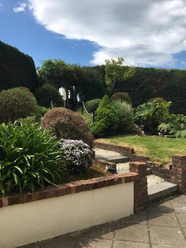 a garden with a brick wall and some bushes at The Shores Country House in Castlegregory